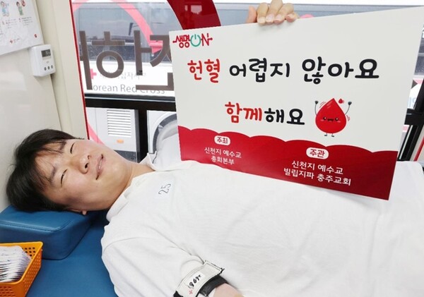 위아원 청년봉사단 충주지부 회원이 헌혈 버스안에서 헌혈을 하며, 헌혈 동참을 독려하고 있다.