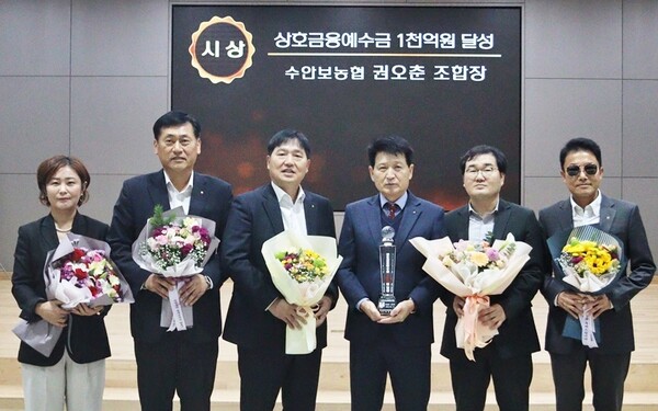 권오춘 수안보농협조합장(왼쪽 네 번째)이 7일 상호금융예수금 1,000억원 달성탑을 수여받고 임직원들과 함께 기념촬영을 하고 있다.